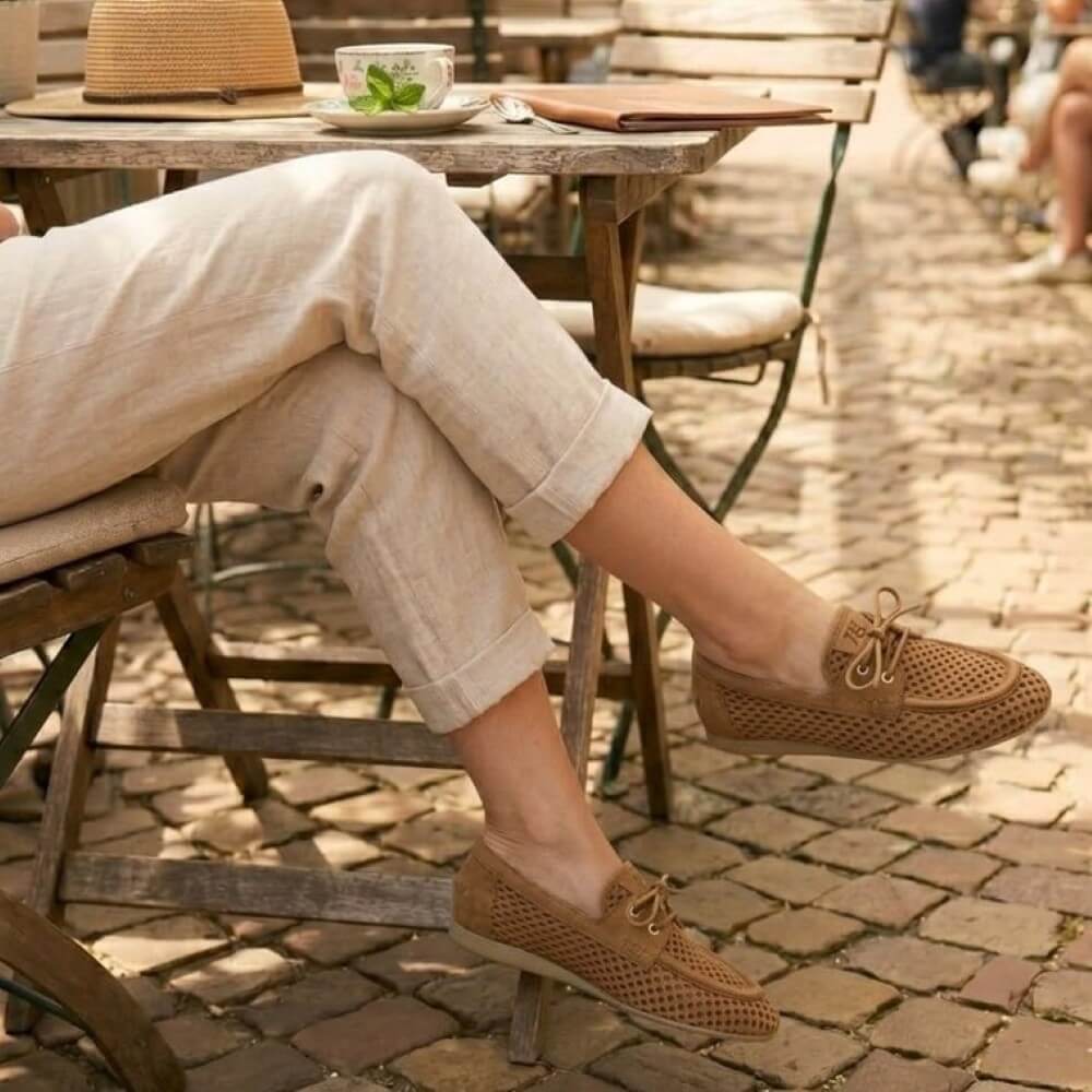Person wearing Paul Green 1218 brown mesh loafers sitting at an outdoor café table.