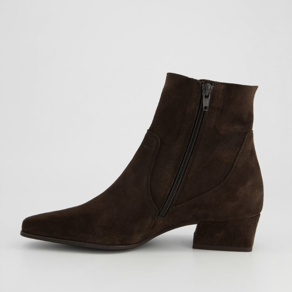 A Paul Green dark brown suede ankle boot with a pointed toe, low block heel, and a black side zipper, shown from a side profile on a light grey background.