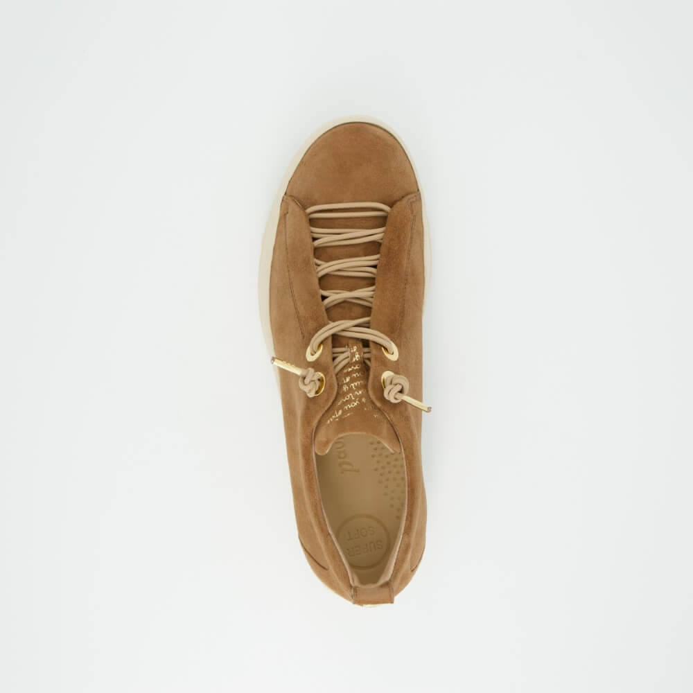 Tan sneaker with white laces on a light gray background