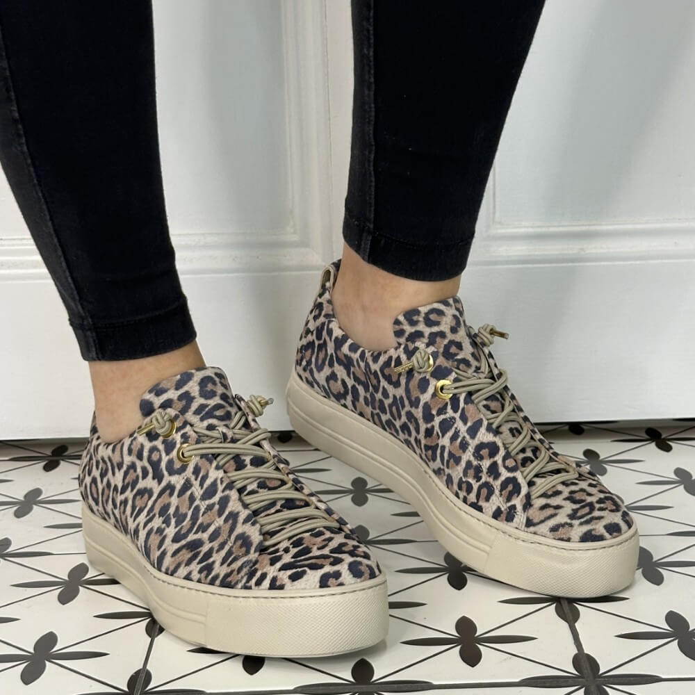 Person wearing a pair of leopard print platform sneakers