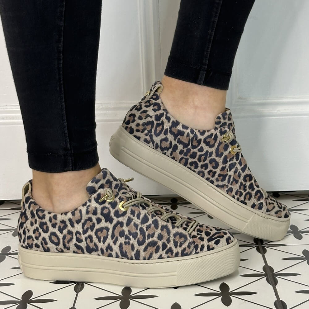 Person wearing a pair of leopard print platform sneakers