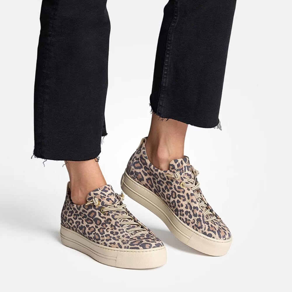 Person wearing a pair of leopard print platform sneakers