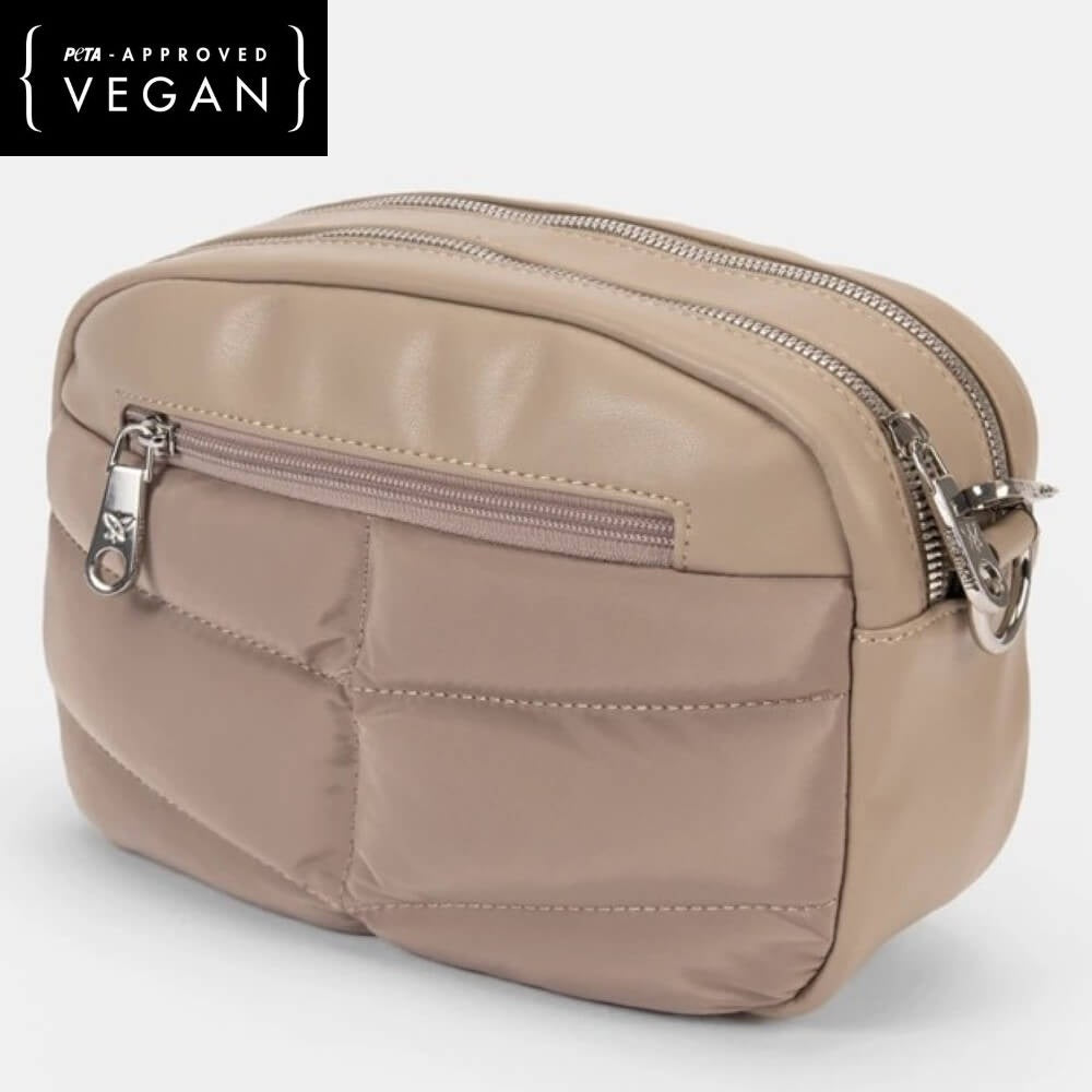 Beige vegan handbag with zippers on a white background, featuring PETA-approved label.
