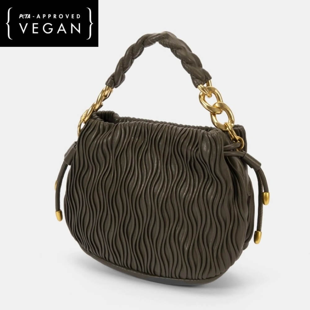 Green textured handbag with braided handle and gold chain on a white background, featuring PETA-approved Vegan label.