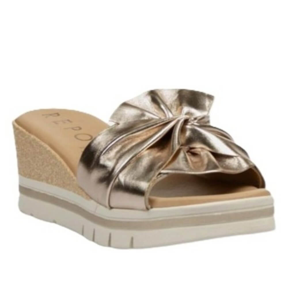 Repo Gold wedge sandal with a bow on a white background