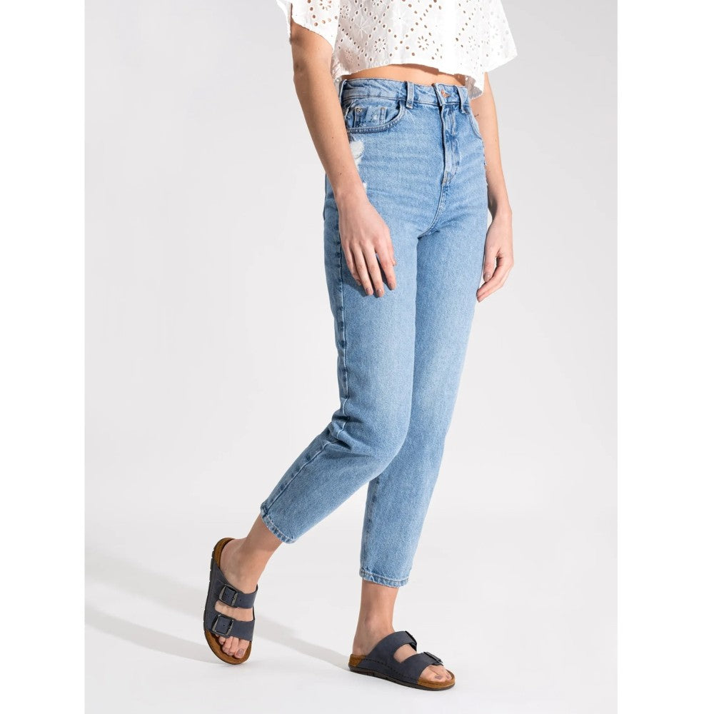Person wearing Rohde navy sandals with light blue jeans on a plain background