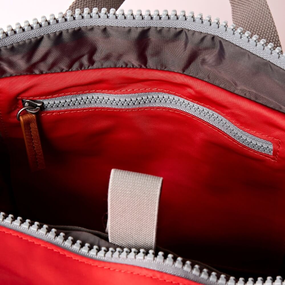 Close-up of a red bag with gray zipper and interior.