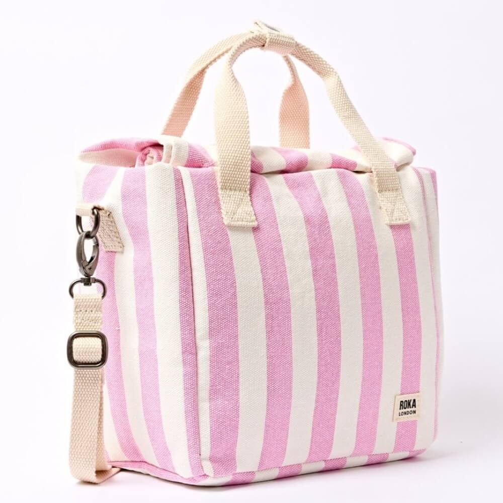 Roka Pink and white striped insulated lunch bag with a shoulder strap on a white background