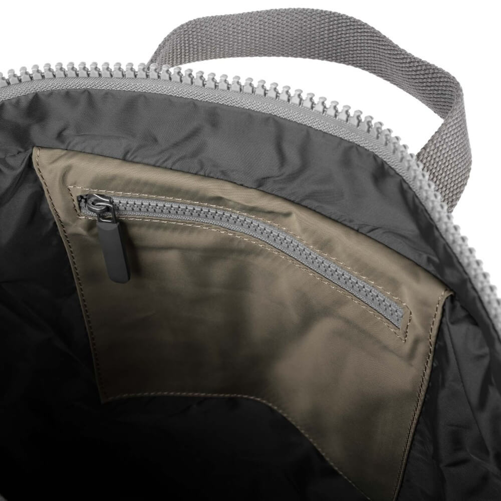 Close-up of a backpack with a zipper and shoulder strap on a white background
