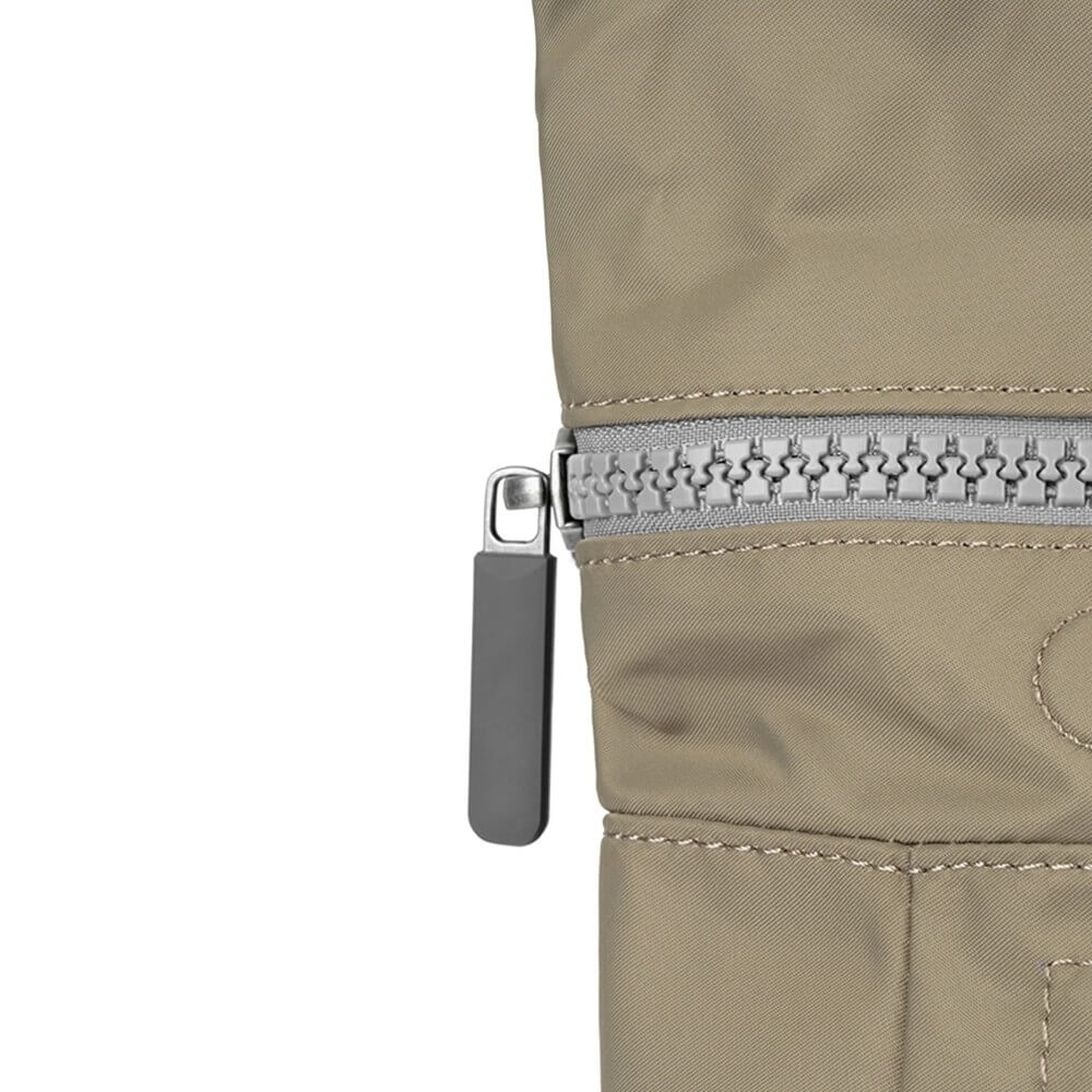 Close-up of a beige jacket zipper on a white background
