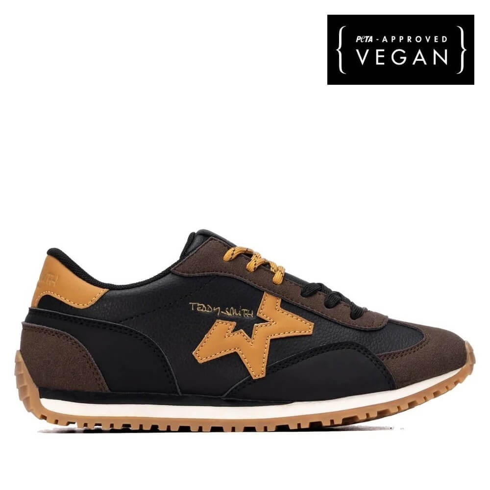 A Teddy Smith low-top sneaker in black and brown with tan accents, featuring a large star logo on the side and a white midsole. A black badge in the top right corner reads 'Vegan Approved'.