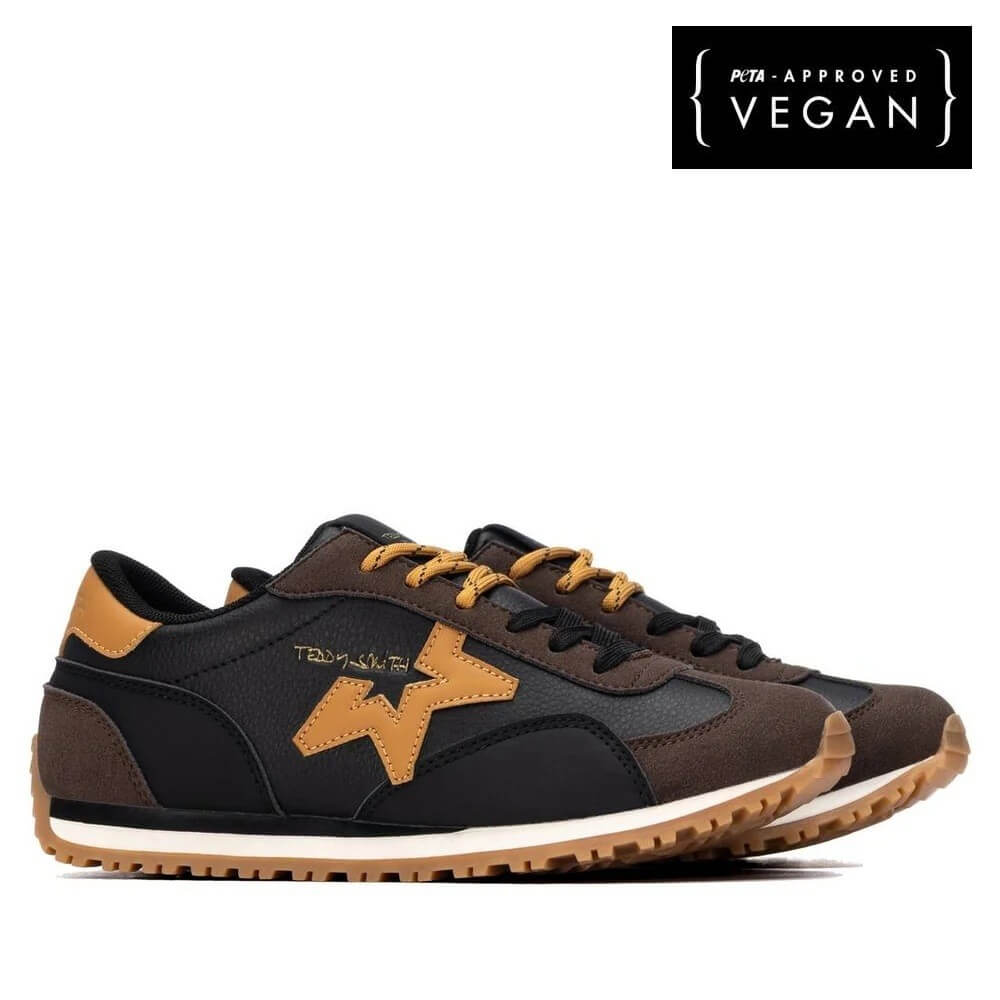 A pair of Teddy Smith low-top sneakers in black and brown with tan accents, shown from the side on a white background. A black square badge in the top right corner reads 'PTA - APPROVED VEGAN'.