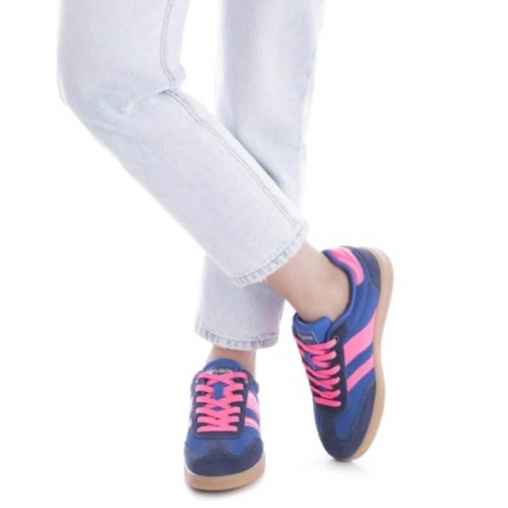 Blue and pink sneakers worn with light blue jeans on a white background teddy smith