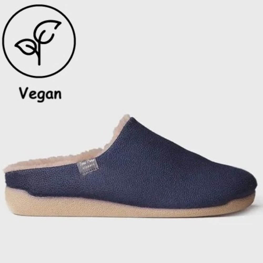 A Toni Pons navy blue slip-on mule slipper with a beige textured sole and cream sherpa lining, shown against a light grey background with a 'Vegan' leaf icon in the top-left corner.