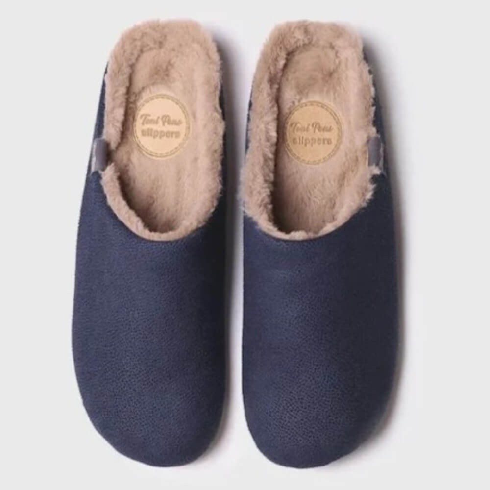 A pair of Toni Pons navy blue slip-on slippers with a soft beige faux fur lining, shown from a top-down view on a light grey background.