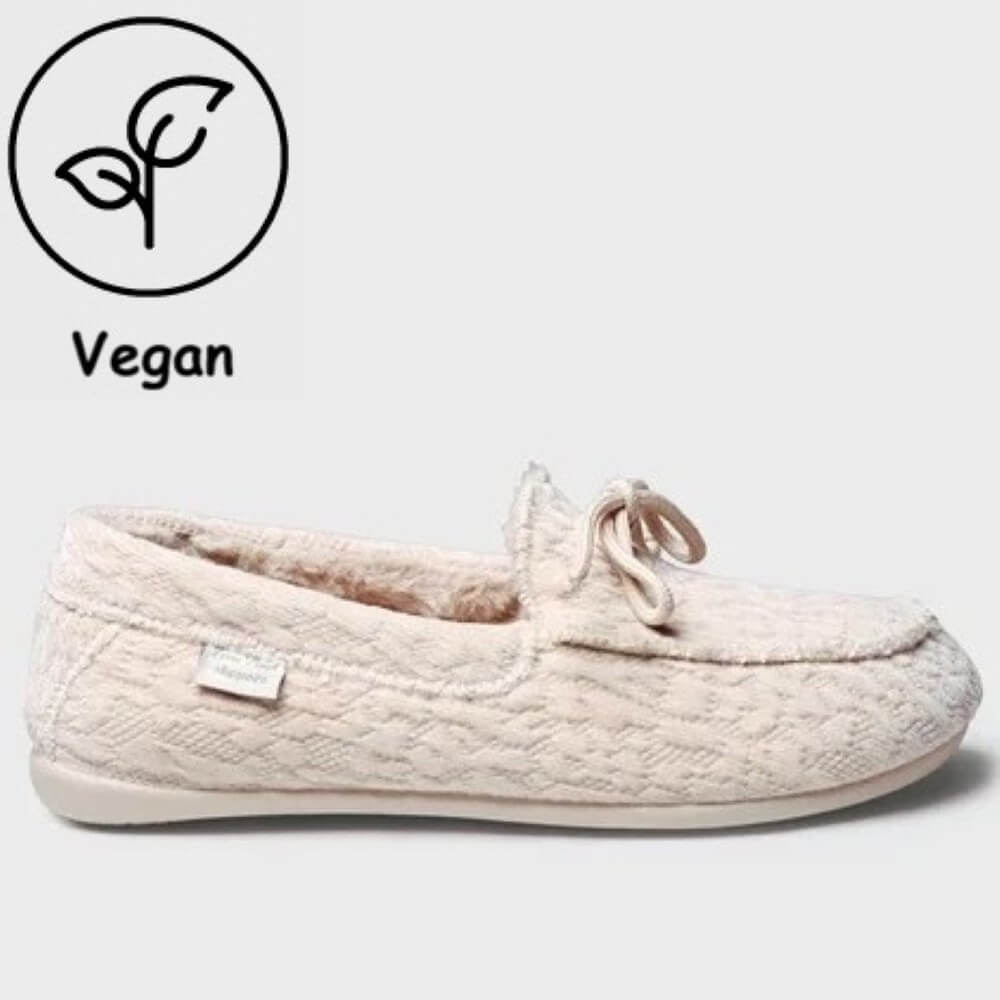 A Toni Pons cream-colored textured slip-on slipper with a small bow detail on the toe, shown against a light grey background with a 'Vegan' leaf icon in the top-left corner.