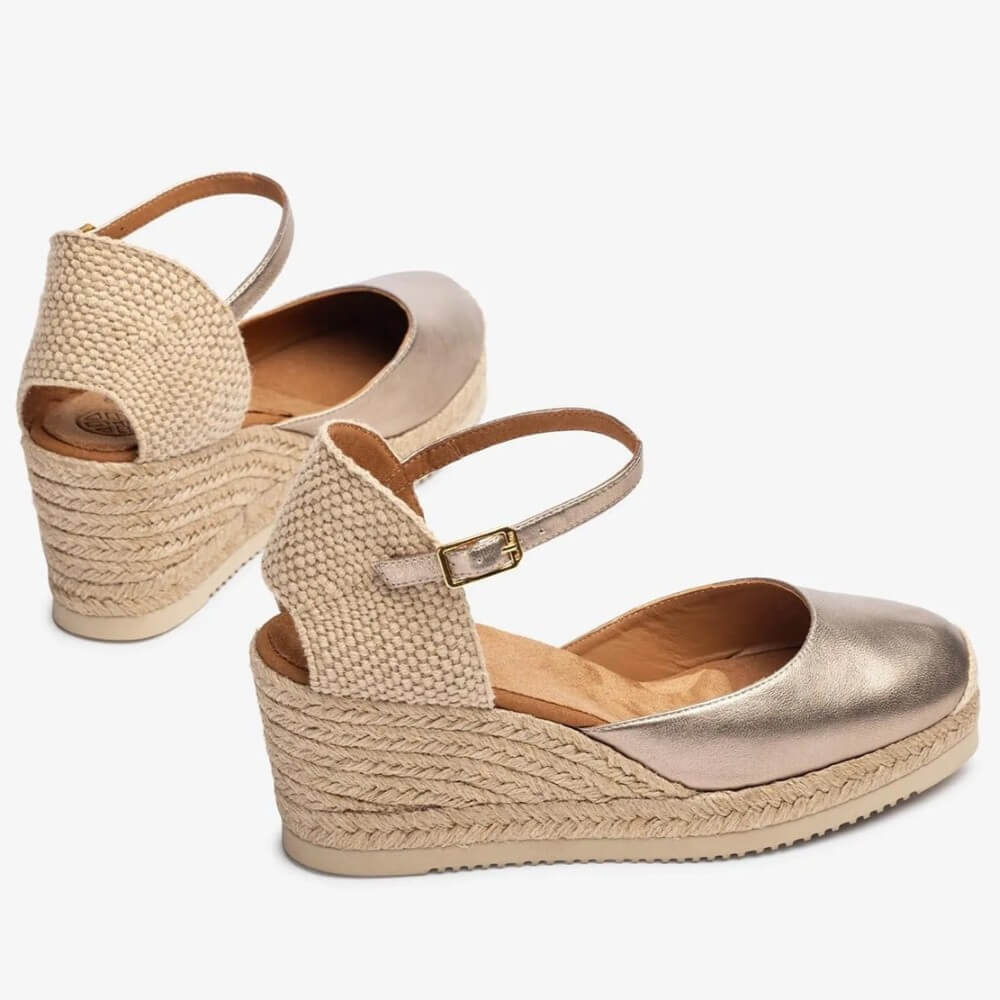 Pair of Unisa metallic wedge sandals with jute sole on a white background