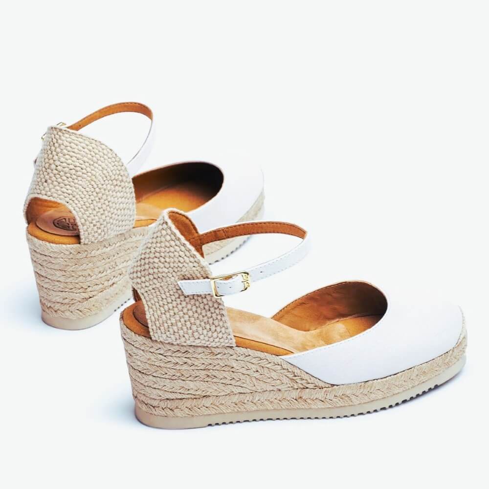 Pair of wedge sandals with woven design on a white background