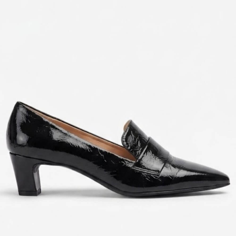 A Unisa black patent leather kitten heel pump with a pointed toe and a small decorative strap detail on the vamp, shown in profile against a light gray background.