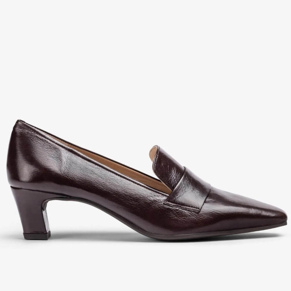A Unisa dark brown leather loafer pump with a pointed toe and a low block heel, shown in profile against a light grey background.