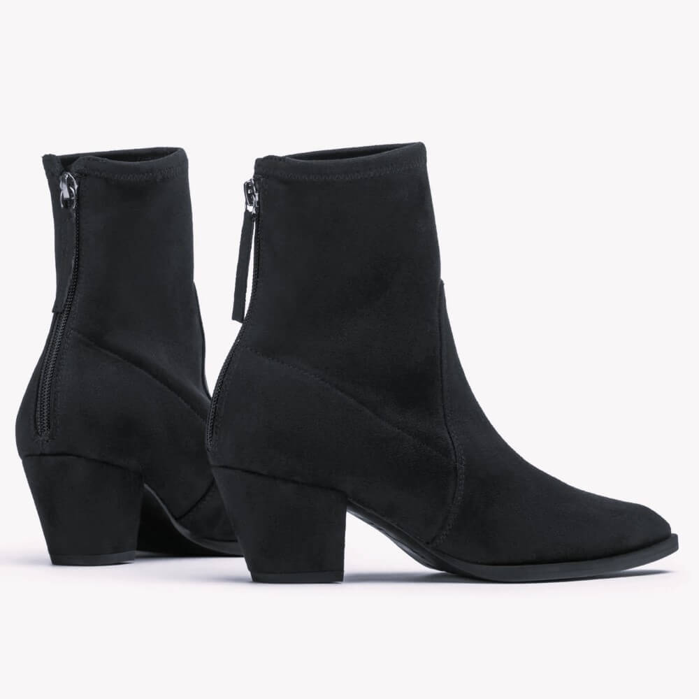 A pair of Unisa black suede ankle boots with block heels and back zippers, shown from the side against a plain white background.