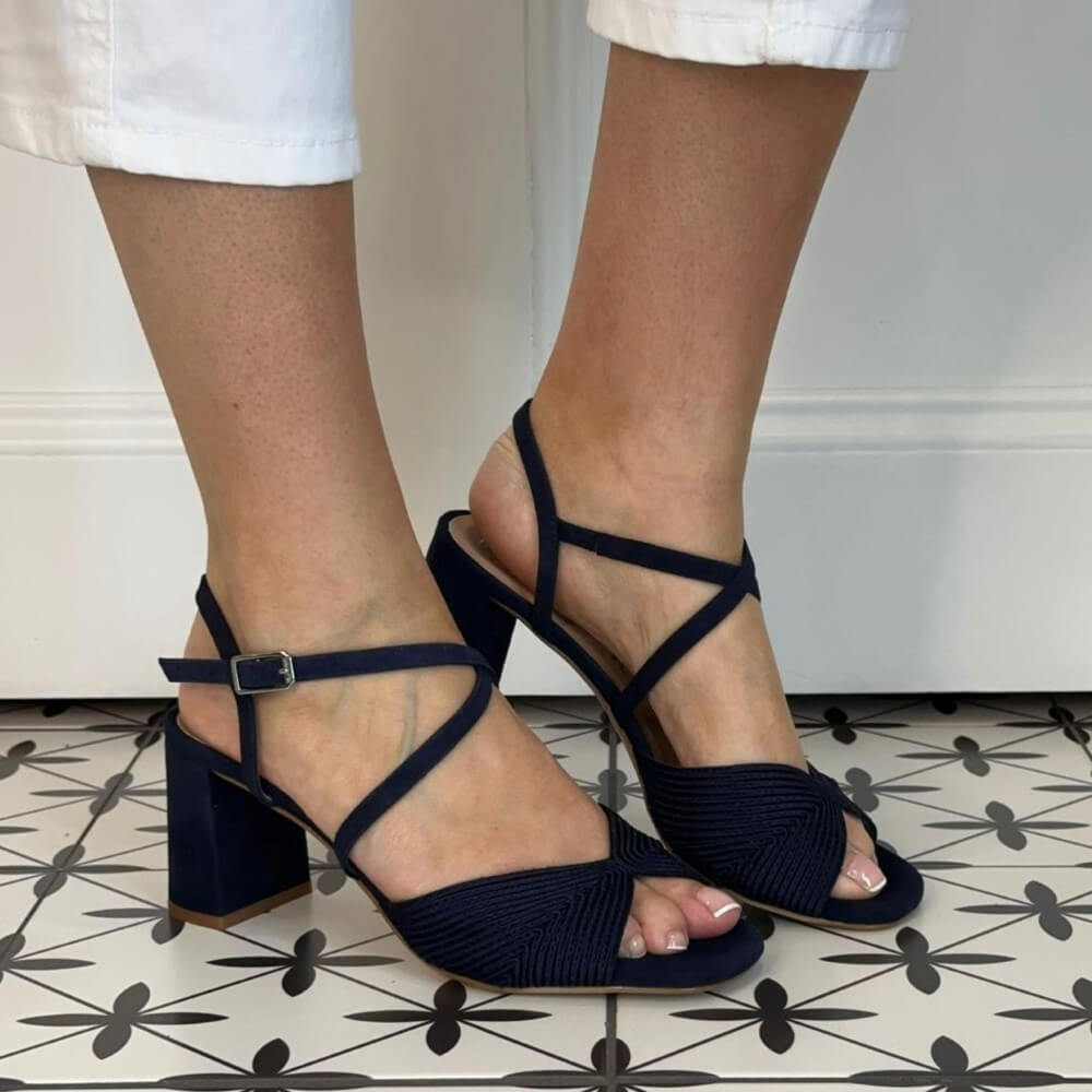 Unisa Navy blue block-heel sandals worn by a person on a patterned floor.