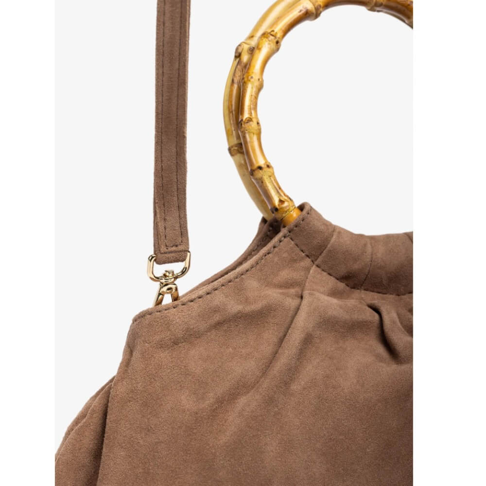 Brown handbag with a gold bamboo handle on a white background