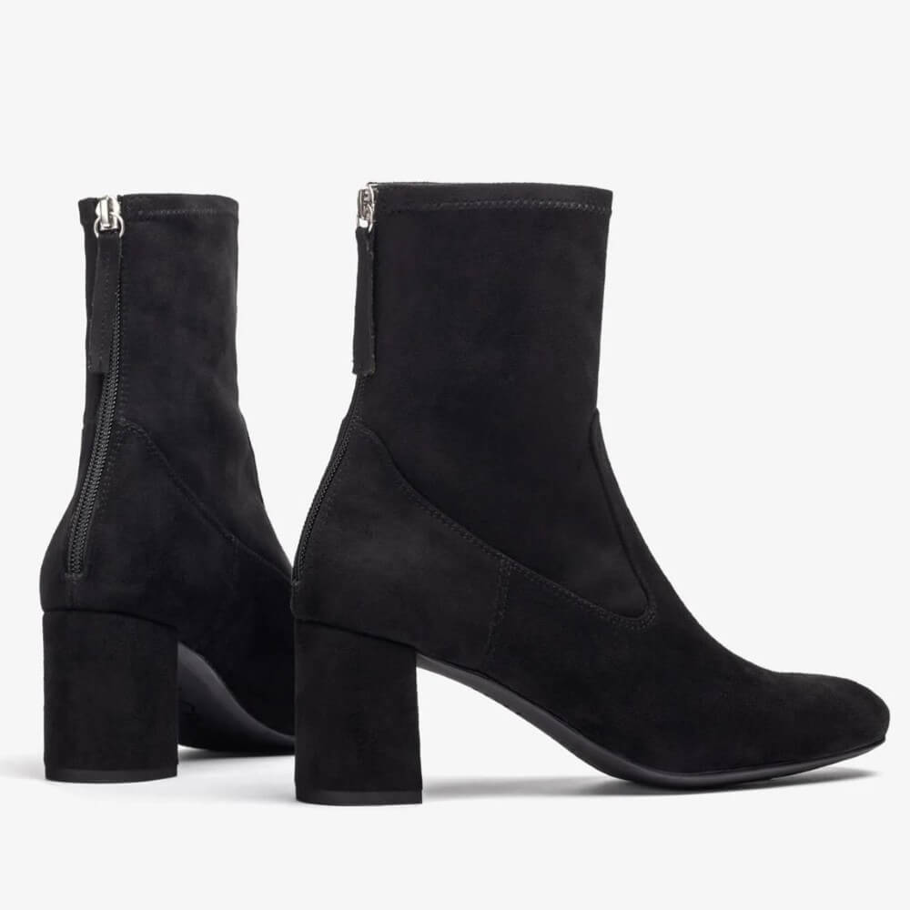 Black suede ankle boots with block heels on a light gray background Unisa Marvy Square toe ankle boot made in faux suede