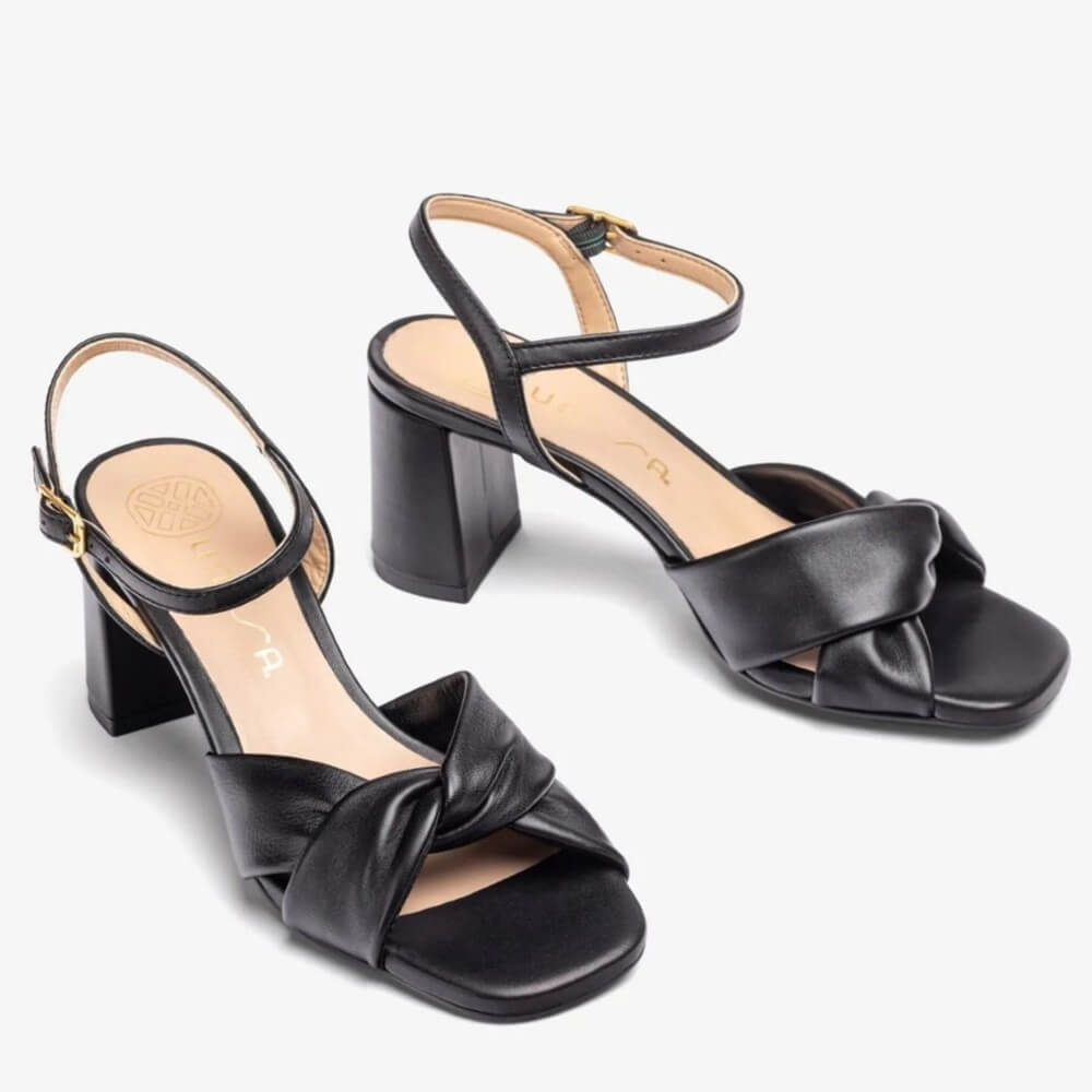 Black Leather sandal with a block heel on a white background. Unisa Medway