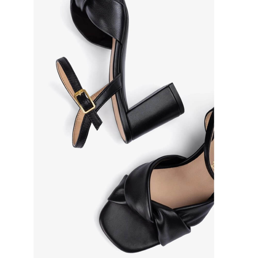 Black Leather sandal with a block heel on a white background. Unisa Medway