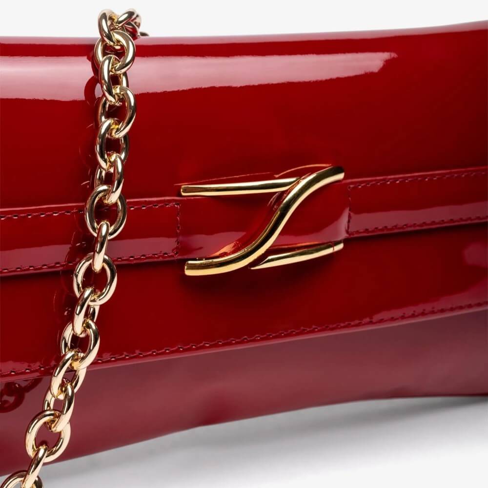 Red handbag with gold chain and clasp on a white background Unisa ZBlair Raspberry Red Patent Shoulder Bag