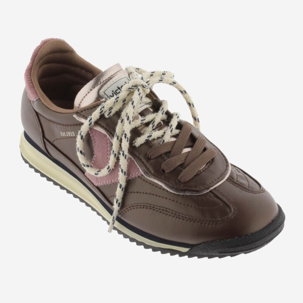 A Victoria brown sneaker with dusty pink accents, cream rope laces, and a black and cream sole, shown from a side profile on a light grey background.