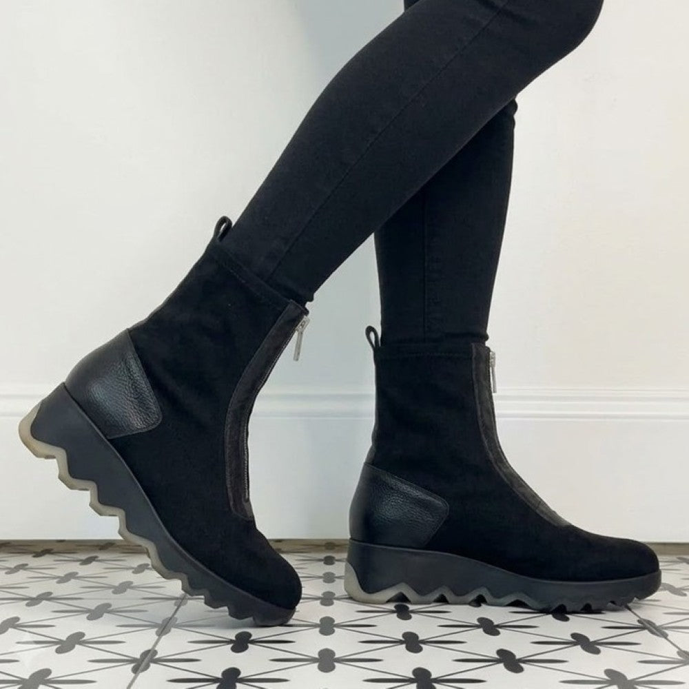 Wonders Black ankle boots with front zippers and textured side panels, worn with black leggings against a white wall.