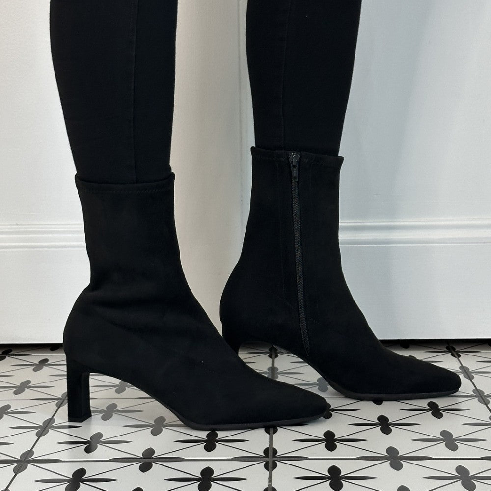 Wonders Black ankle boots with a pointed toe and block heel, worn with black leggings on a patterned black and white tile floor.