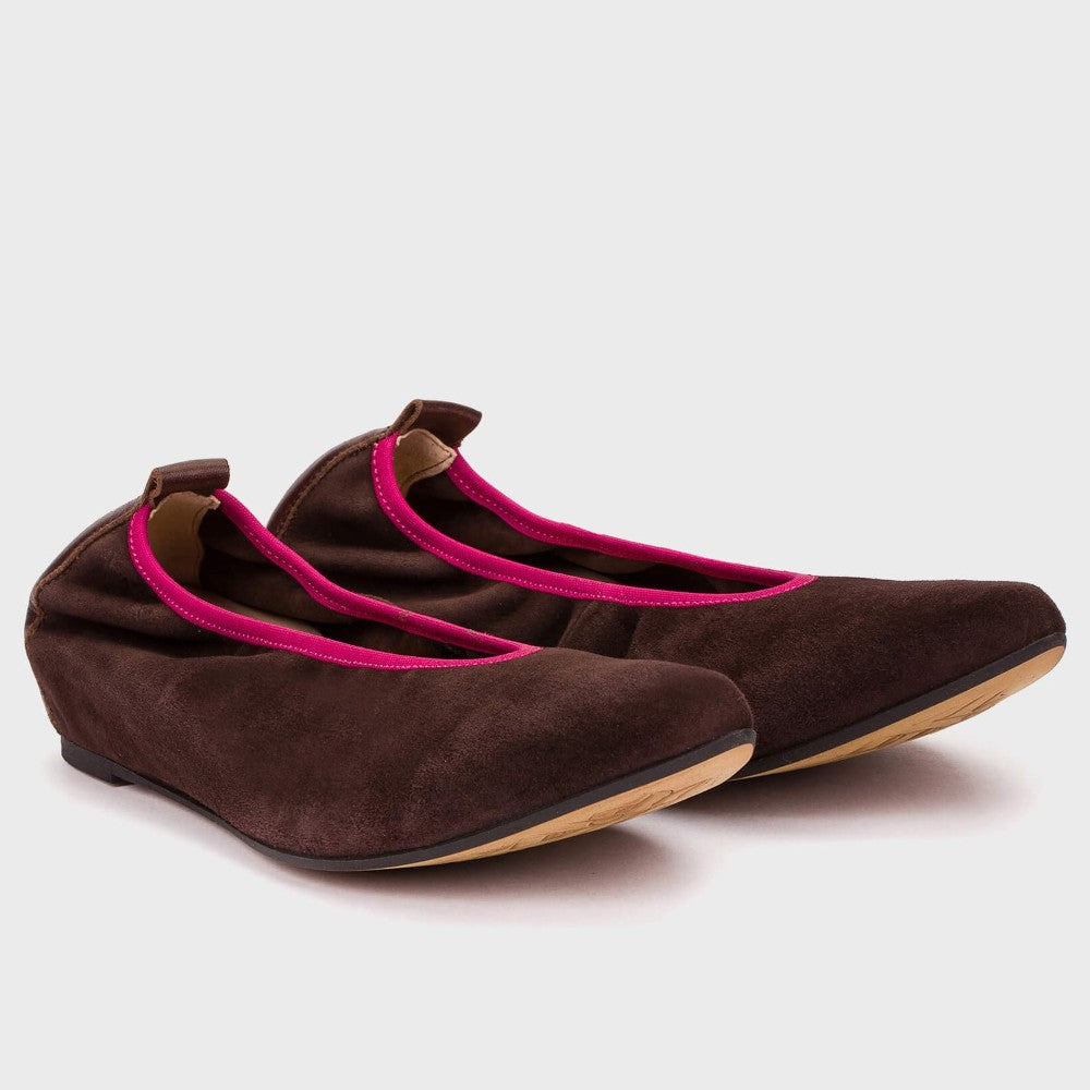 Pair of brown shoes with pink interior on a light gray background