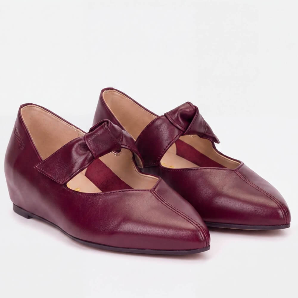 A pair of Wonders women's Mary Jane flats in burgundy leather with bow straps, shown on a clean white background.