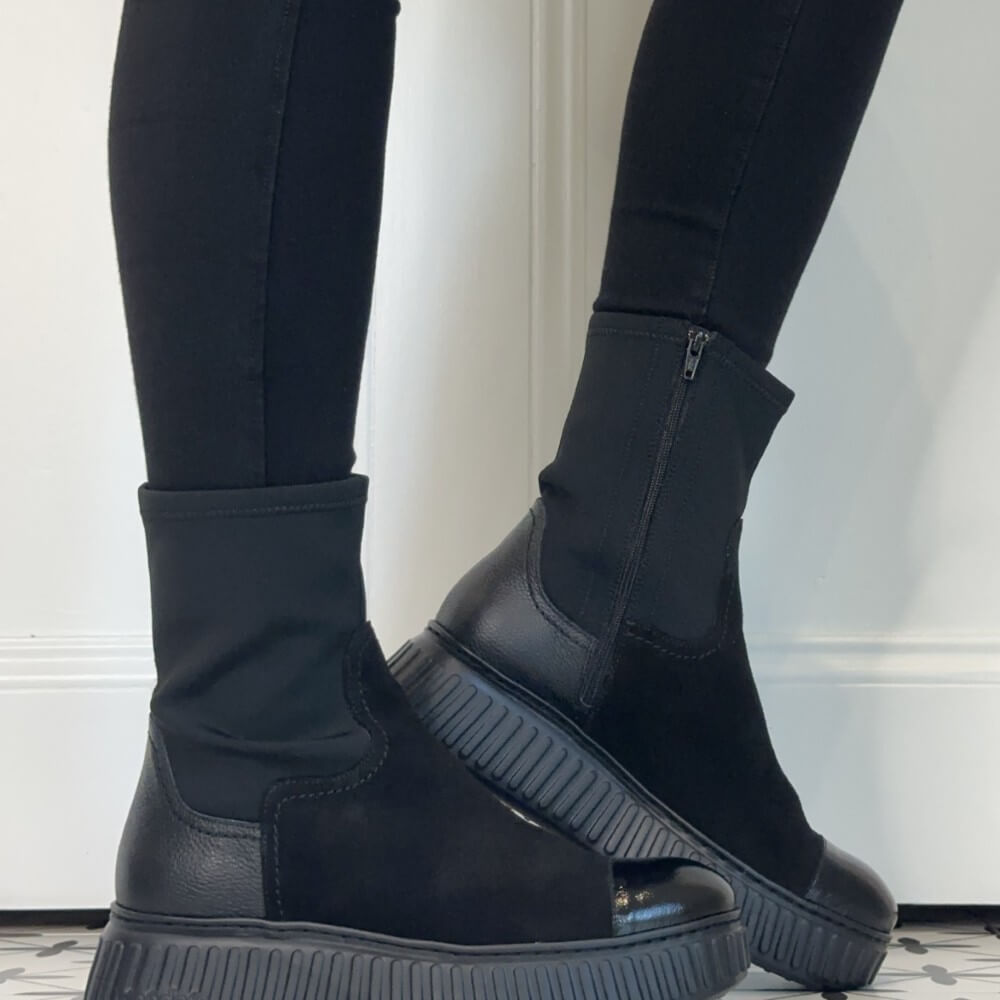 Wonders Black mid-calf boots with a glossy patent leather toe cap and chunky lug sole, worn with black leggings.