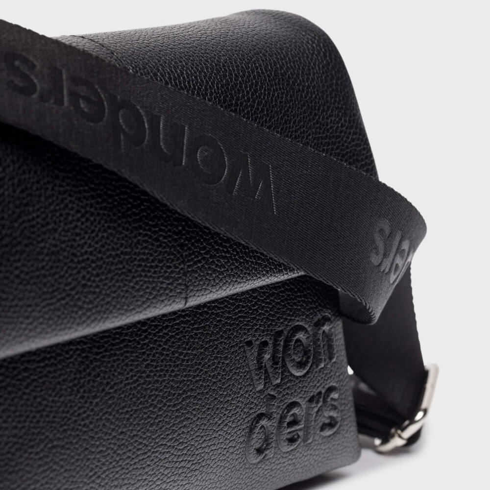 Black shoulder bag with 'wonders' branding on a white background