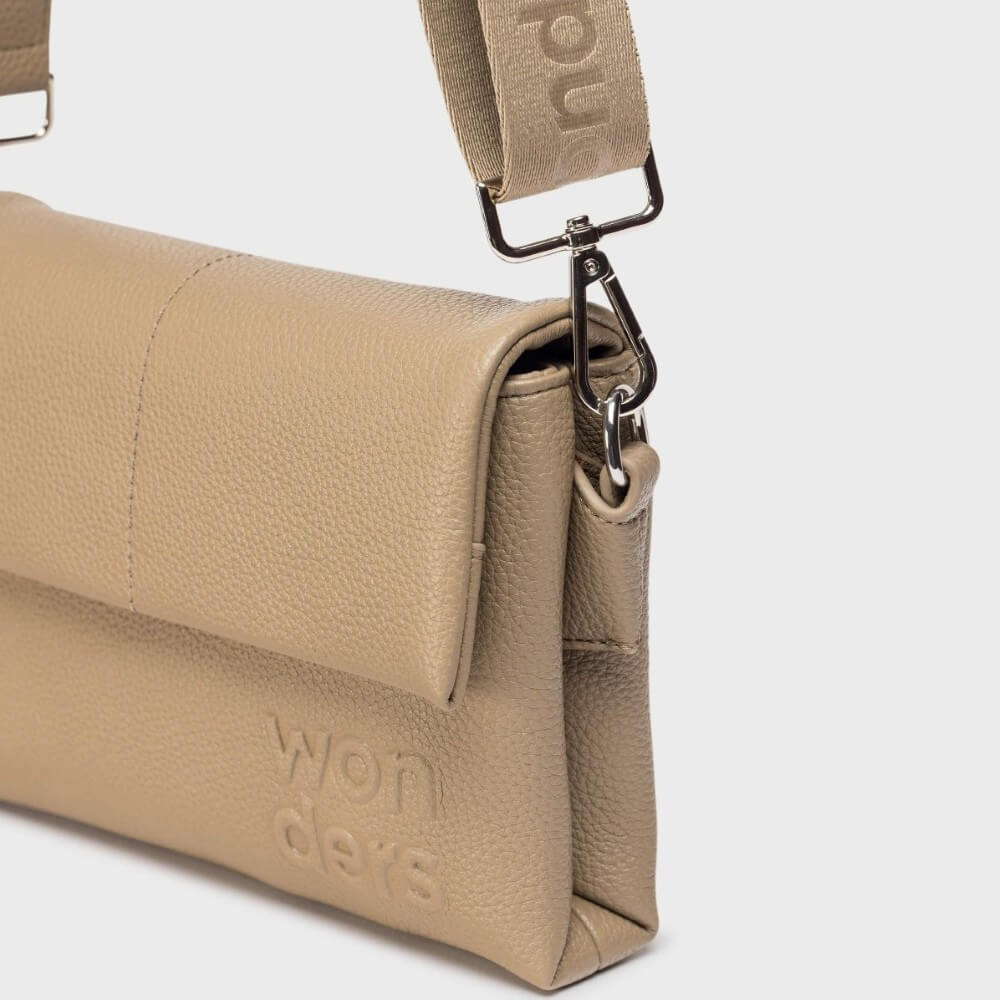Beige crossbody bag with 'wonders' branding on a light grey background