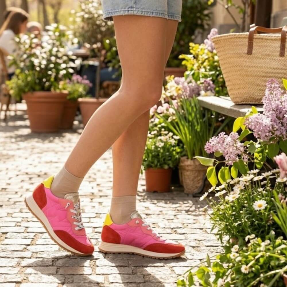 Person wearing pink sneakers with a garden in the background