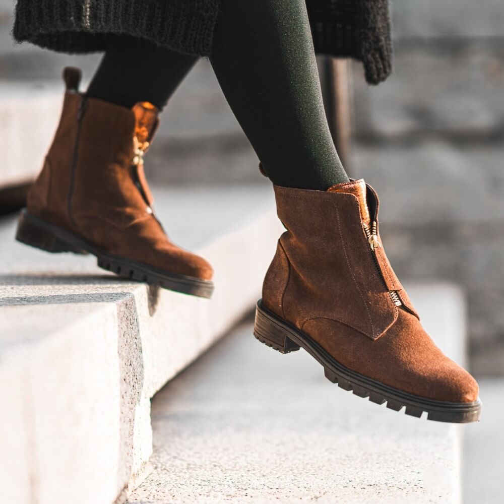 Brown boots worn by a person sitting on a concrete surface. Ara Tulsa Suede Leather Ankle Boots 12-29520 Brown