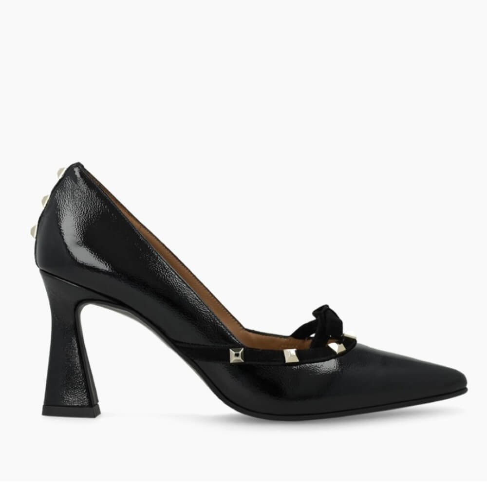 Black high-heeled shoe with decorative bow and studs on a white background Lodi RERIS pumps in black patent leather