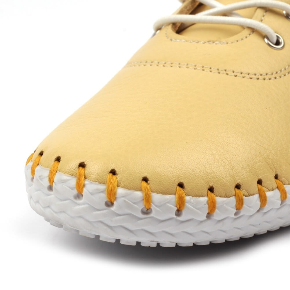 Yellow shoe with white sole and orange stitching on a white background