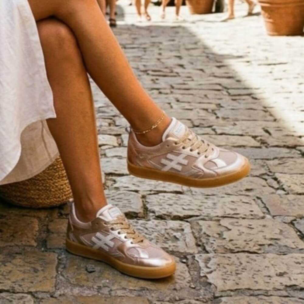 Person wearing beige sneakers on a stone pavement