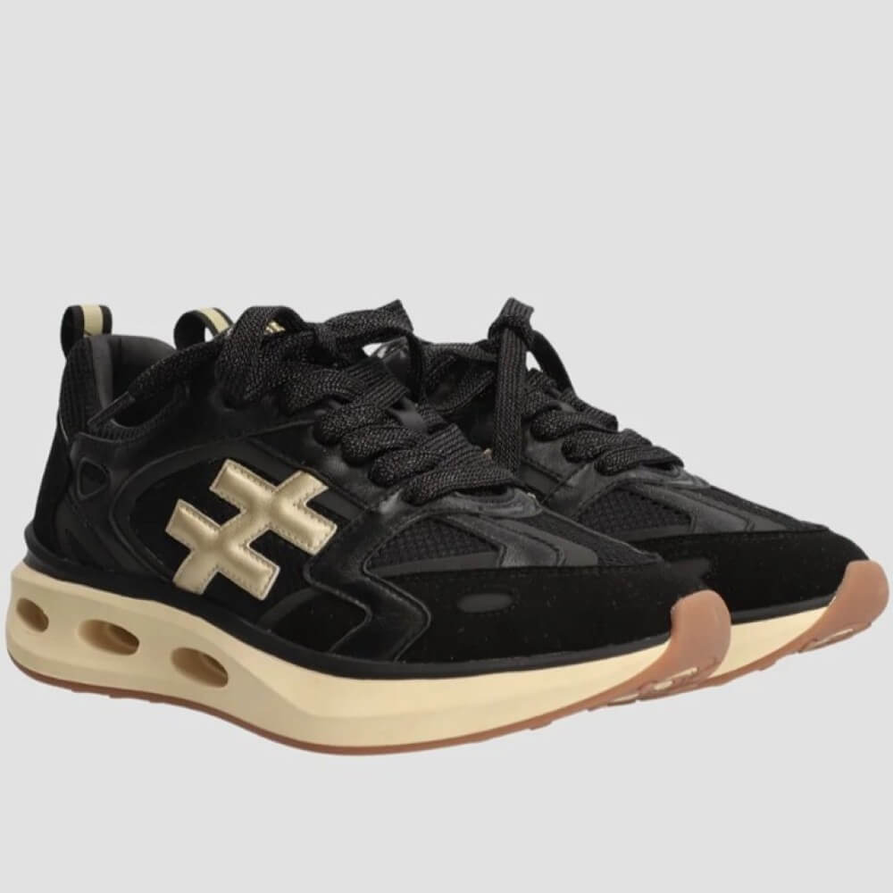 Black sneakers with gold accents on a light gray background