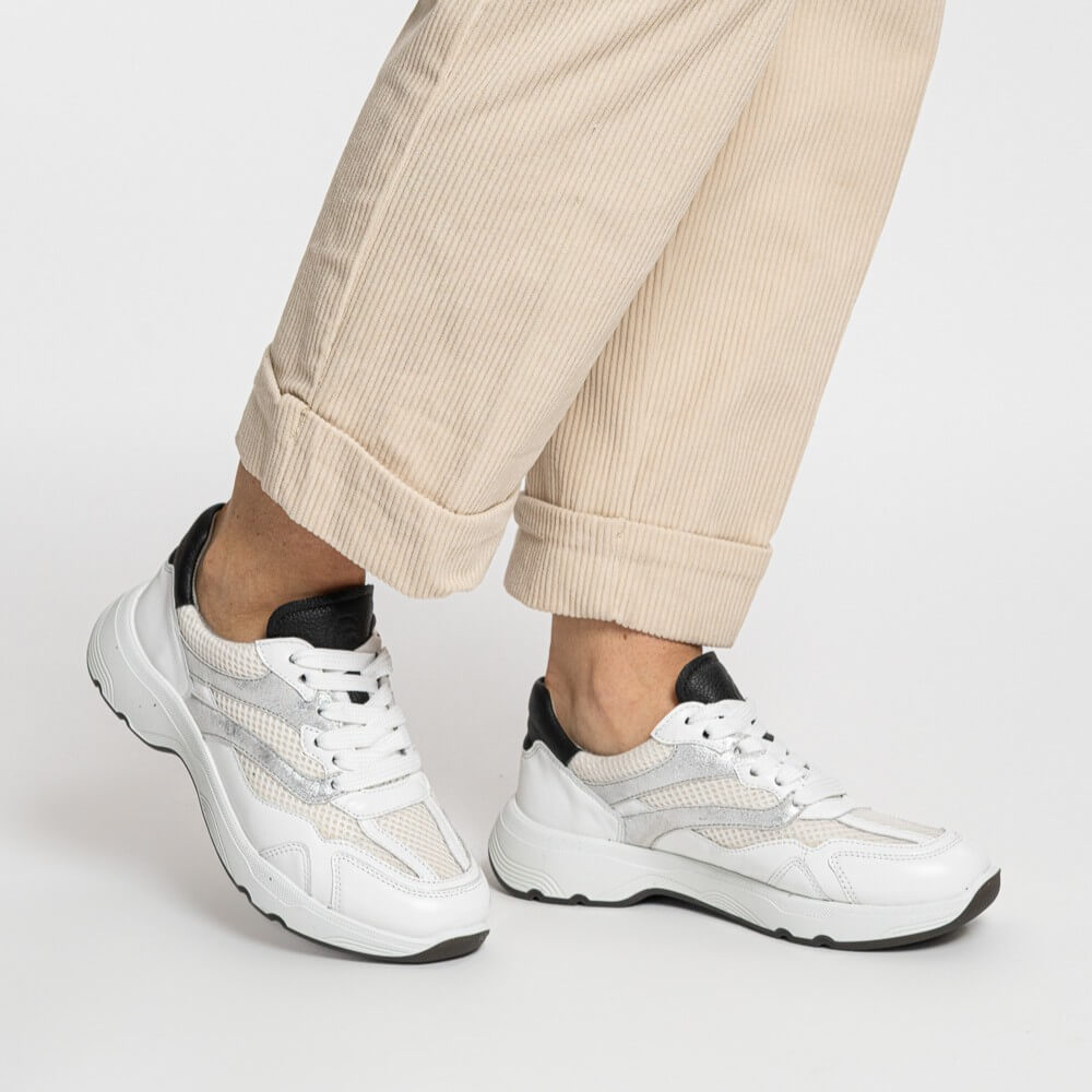 person wearing ara 12-25804 boston White sneakers with black accents on a white background