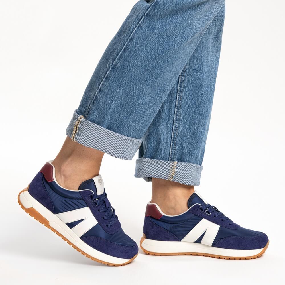 Ara Navy sneakers with white accents worn with rolled-up jeans on a light background