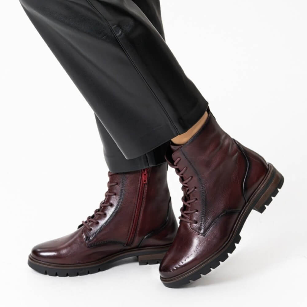 Wine leather boots worn with black pants on a white background Ara Cambridge Laced Leather Ankle Boots 12-11260 Wine