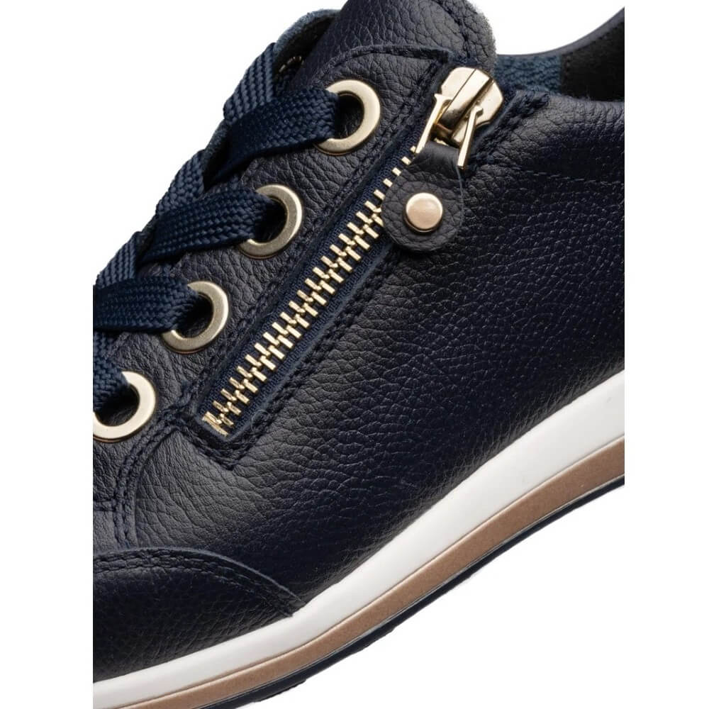 Navy blue sneaker with gold zipper and eyelets on a white background