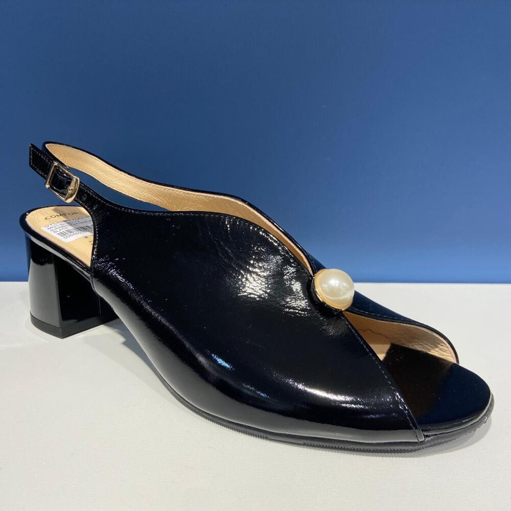 Bioeco Black sandal with a pearl accent on a white surface and blue background